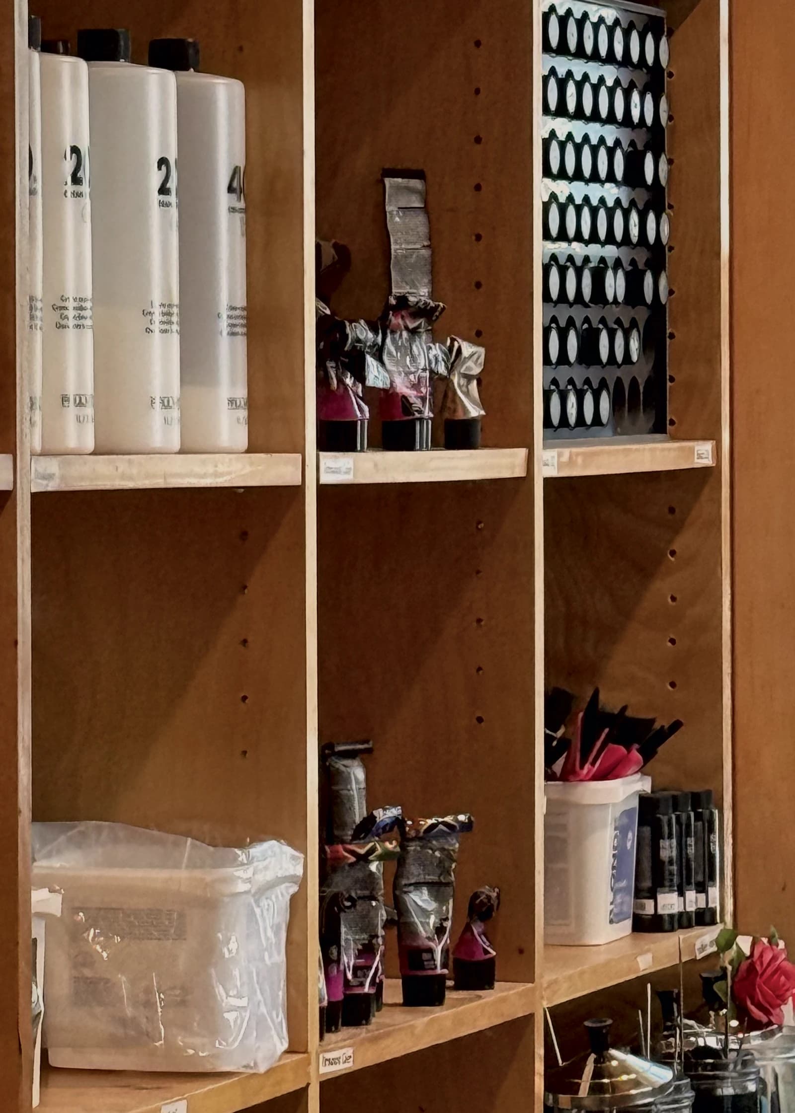 Color tubes, foil packets and tint brushes on the maple shelves of the color bar